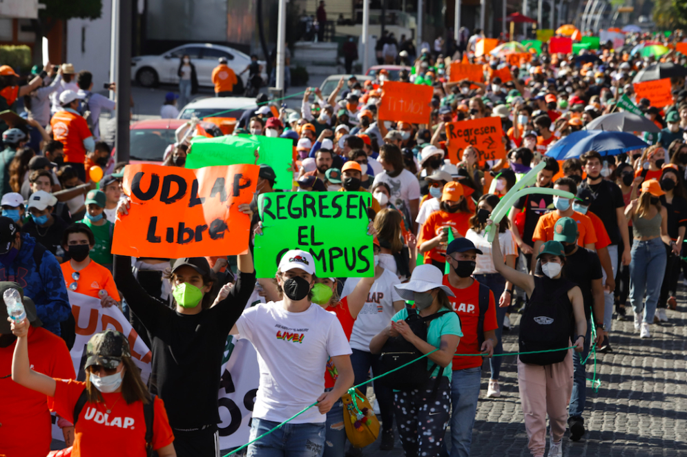 Marchan estudiantes de la UDLAP exigiendo liberación del campus; inundan la recta de color naranja